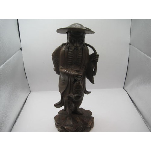 139 - Chinese or Far Eastern carved wood figure of fisherman with wide brimmed hat and carrying two fish o... 