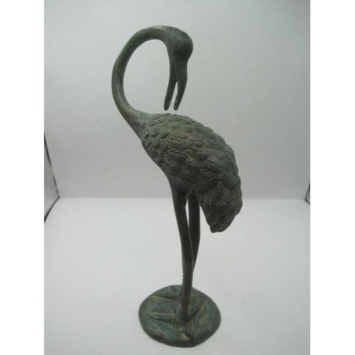 134 - A pair of verdigris bronze birds, perhaps storks or herons, on round bases, heights 26cm and 25cm