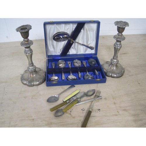 109 - A selection of Silver plate to include two candle sticks several small cutlery items including a pro... 