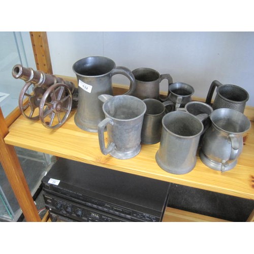 132 - A series of graduated pewter tankards along with a cast iron cannon