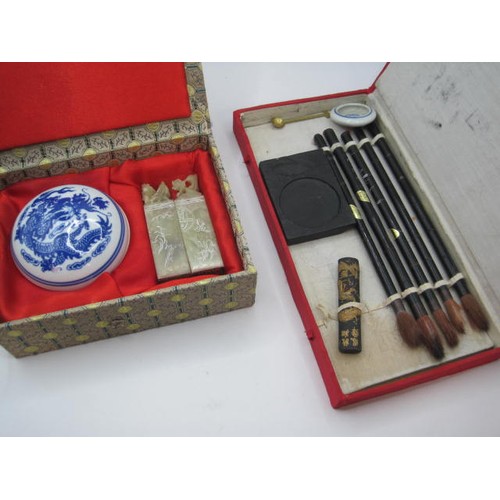 39 - A Chinese ink seal kit in a cloth clad box, and a Chinese brush painting kit in a case labelled Zhon... 