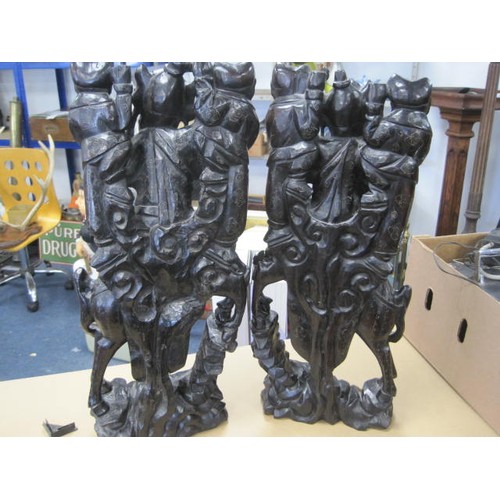 45 - An imposing pair of Chinese or Far Eastern carved wood groups each with warrior on horseback and two... 