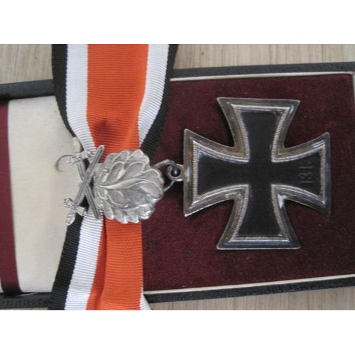 239 - A WW2 Knight's Cross with oak leaves and swords, with ribbon, in a fitted box which is designed for ... 