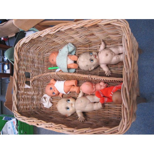 242 - A vintage wicker basket containing a number of antique dolls