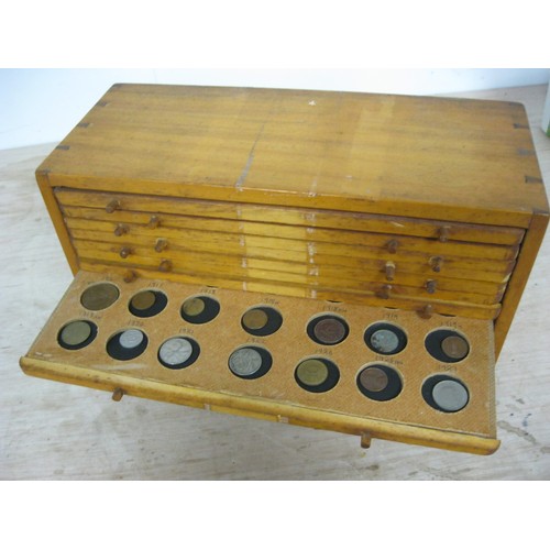 139 - A vintage wooden coin collector's cabinet of 14 trays, each to hold 21 coins giving storage for a to... 