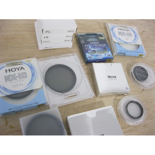 86 - A box of camera lens filters by Hoya and others to fit various size lenses, all in protective packag... 