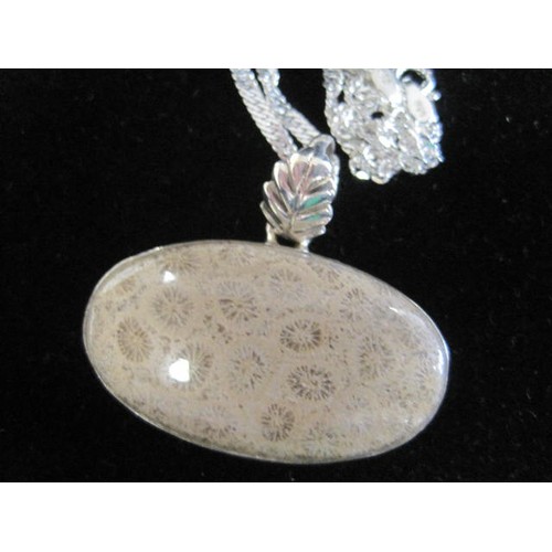 34 - 925 silver oval pendant set with a polished fossil style stone, leaf-shape suspension loop, on a cha... 