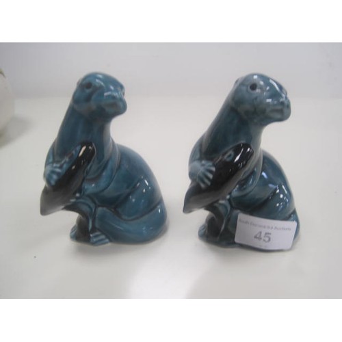 45 - Pair of Poole Pottery blue glaze otters with fish, height 11.5cm. One might be a seconds (a/f mark t... 