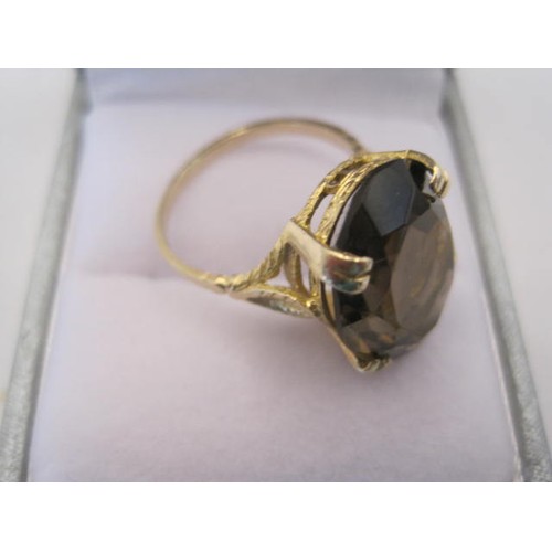 237 - 9 carat gold smoky quartz ring, the faceted oval quartz about   17.5mm x 13mm, (a/f a couple of smal... 