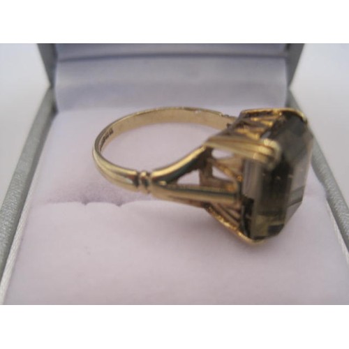 238 - 9 carat gold ring set with a large grey stone of rectangular cut (about 12mm x 9.5mm) in a claw sett... 