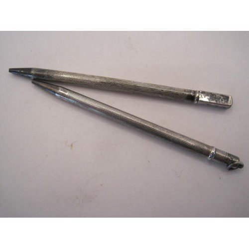 248 - Two silver propelling pencils, each about 9cm long with engine turning, one stamped sterling silver ... 