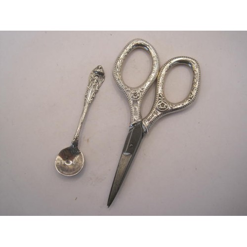 249 - Silver handled sewing scissors and a condiment spoon - the scissors with steel blades, embossed silv... 