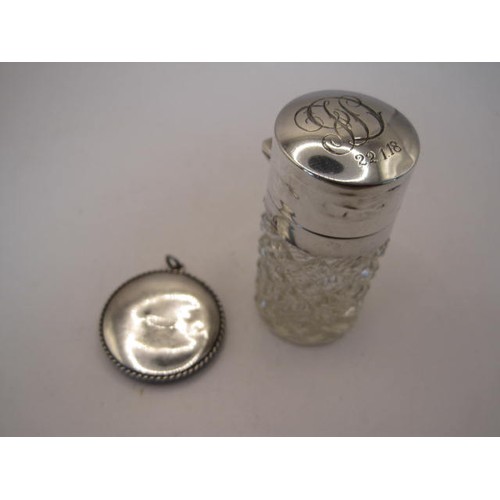 250 - Silver mounted dressing table bottle together with a pendant. Height of bottle 6.5cm, diameter about... 