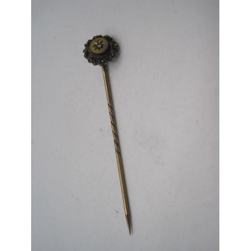 259 - Victorian yellow metal stick pin, the round terminal with chip white stone in star engraved setting,... 