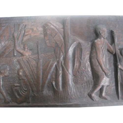 128 - An African hardwood relief carving of people, animals and trees by Munorgo Gehard, in good order