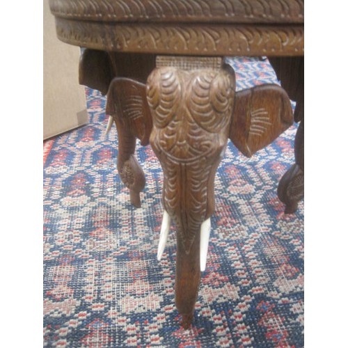 147 - A small Oriental - likely Thai - side table with ornately carved top, sides and legs featuring eleph... 