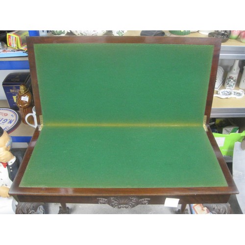 166 - A Games table with folding top lined with green baize sat upon sweeping claw legs