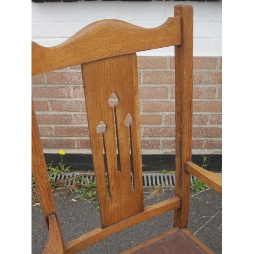 65 - An oak armchair and a stick stand. The splat of the armchair pierced with stylized tulips, leatheret... 