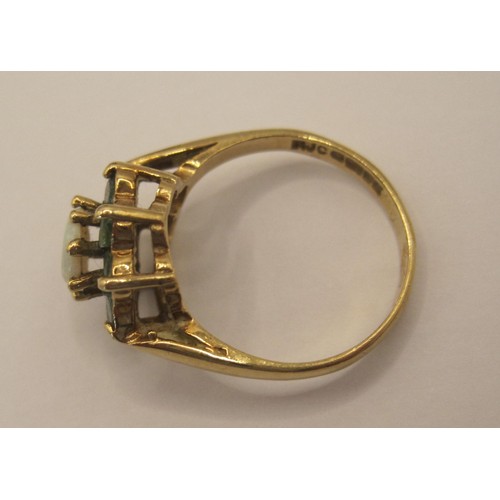 164 - A 9 carat gold ring with central opal surrounded by 8 emeralds, approx weight 3.1g