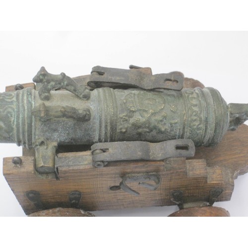 177 - An ornate bronze model of a cannon on an oak carriage