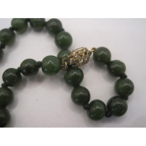 65 - Necklace of green glass or mineral beads, length about 47cm, with an 9 carat gold clasp set with ver... 