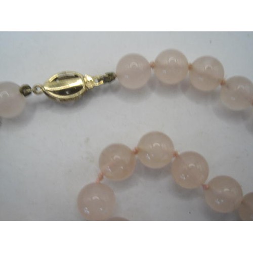 67 - Necklace of rose quartz beads with a 9 carat gold clasp set with small white faux stones. Length of ... 