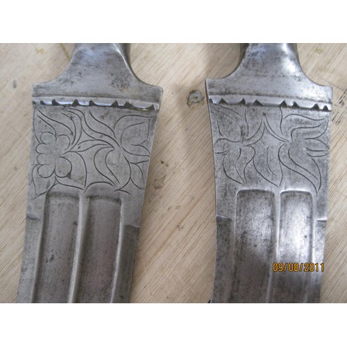 51 - A pair of Arabian or Middle Eastern daggers, decorated blades, both in good order, no scabbards