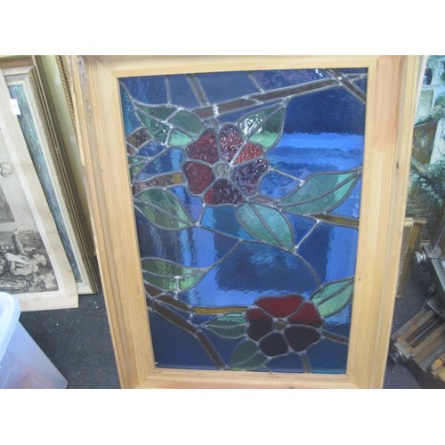 45 - A stained leaded glass panel in a deep pine frame.  Red flowers and green leaves against a blue grou... 