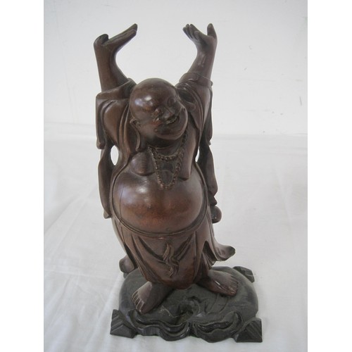 29 - A Chinese carved wooden figurine of a laughing Budda on ebonized base