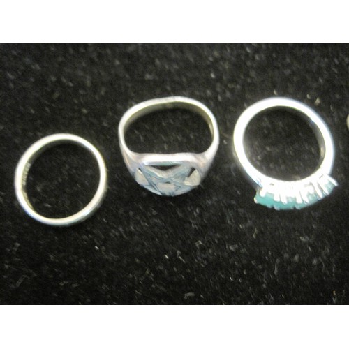 162 - Three dress rings and two charms. (1) White metal dress ring set with four opaque green glass stones... 