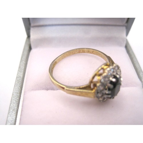 210 - A silver gilt dress ring set with a dark oval stone surrounded by twelve white stones, ring size N, ... 