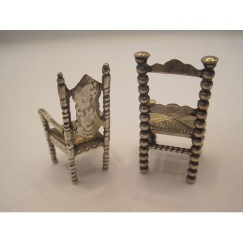 214 - Two foreign silver miniature chairs. (1) ladderback, height 4cm, indistinct stamped marks, 13.9g. (2... 