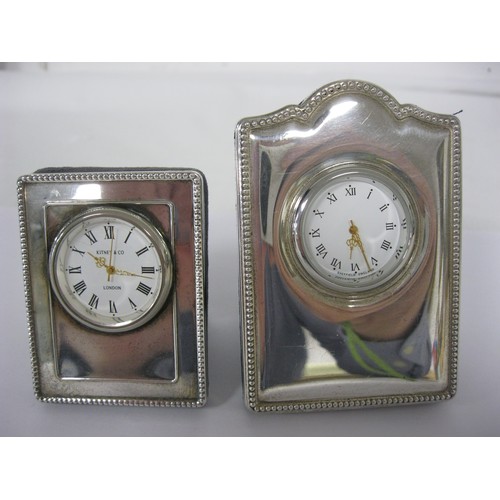 218 - Two silver mounted quartz mantel clocks, each with blue velvet backs and photo frame style stands. (... 