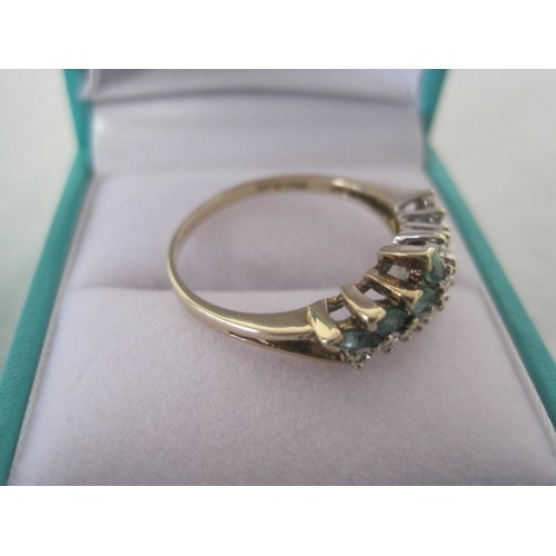 110 - 9 carat gold ring set with a spray of eight marquise emeralds and eleven small white stones, ring si... 