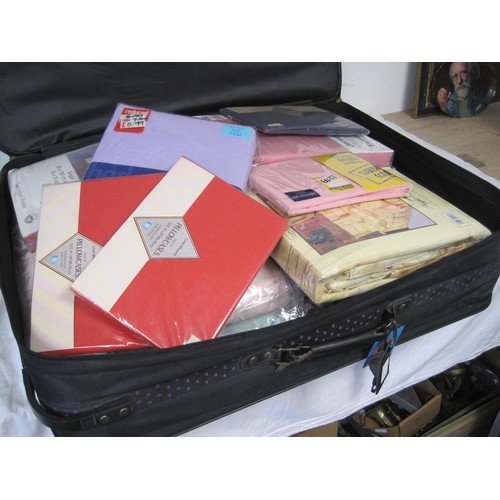 194 - A woven nylon suitcase full of unopened packs of bed sheets, pillow cases, etc, mainly for single be... 