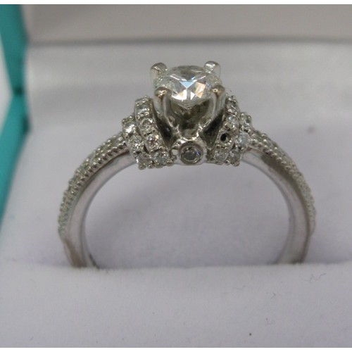 228 - An 18 carat white gold solitaire diamond ring. The central stone estimated at 0.5 carat, with furthe... 