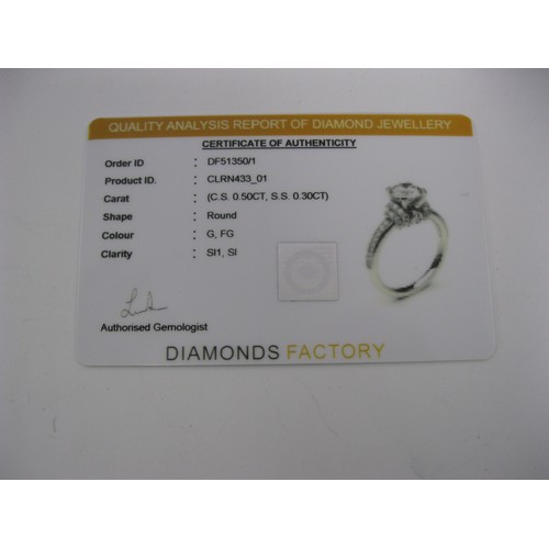 228 - An 18 carat white gold solitaire diamond ring. The central stone estimated at 0.5 carat, with furthe... 