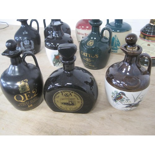 47 - A collection of stoneware whiskey jugs including commemoratives