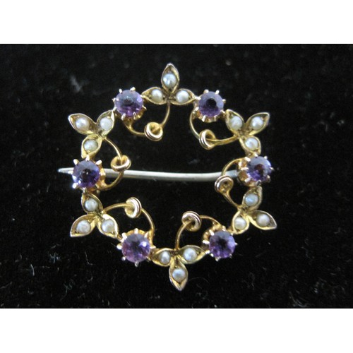 82 - A 9ct gold brooch of circular form set with six amethyst and small pearls 2.4g