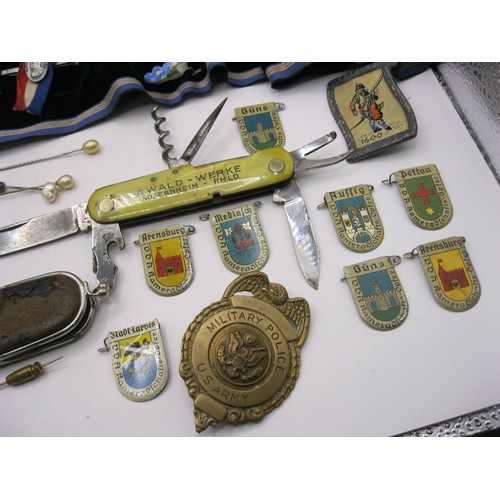 91 - A selection of pre-war German badges featuring the arms of various cities, a roll of other badges an... 