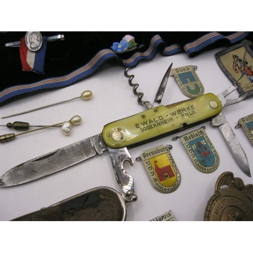 91 - A selection of pre-war German badges featuring the arms of various cities, a roll of other badges an... 