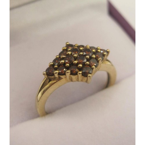 172 - A 9 carat gold ring with a lozenge-shape setting of sixteen small red stones, ring size J, gross wei... 