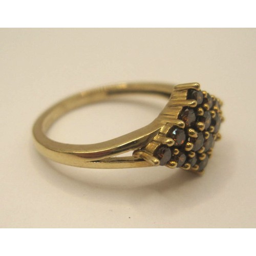 172 - A 9 carat gold ring with a lozenge-shape setting of sixteen small red stones, ring size J, gross wei... 