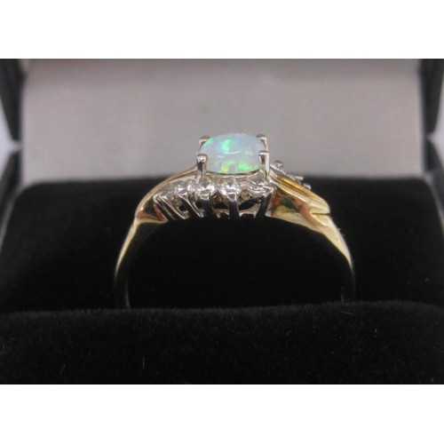 176 - 9 carat gold ring set with an opal (estimated 4.5mm x 3mm) between ten cubic zirconia stones, ring s... 