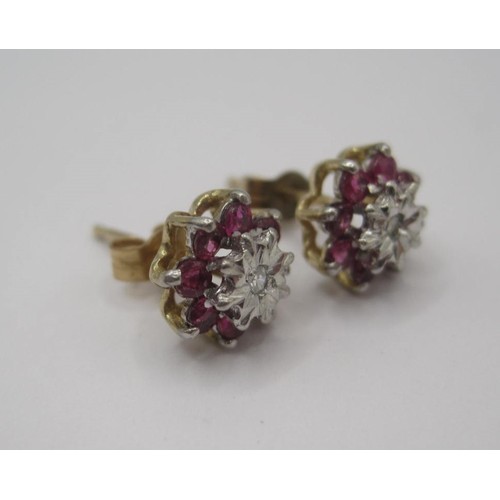 178 - A pair of 9 carat gold ruby and diamond earrings. Each earring set with a small central diamond surr... 