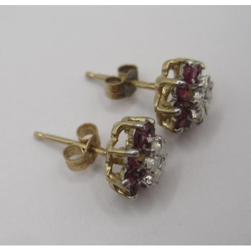 178 - A pair of 9 carat gold ruby and diamond earrings. Each earring set with a small central diamond surr... 