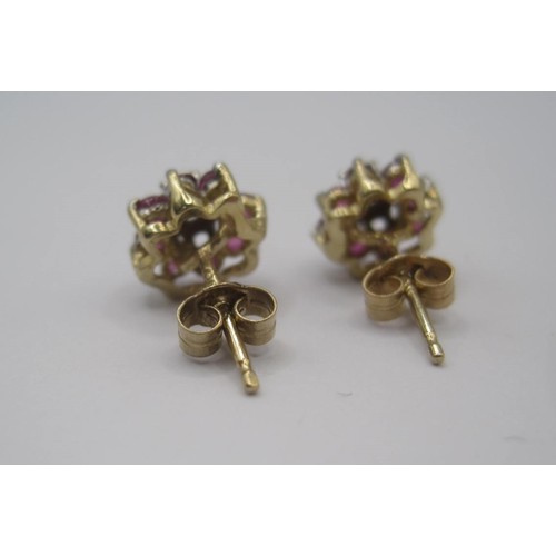 178 - A pair of 9 carat gold ruby and diamond earrings. Each earring set with a small central diamond surr... 