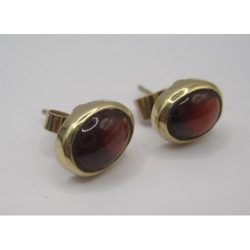 180 - Pair of cabouchon garnet earrings in yellow metal settings, one of the retainers stamped 375. With a... 