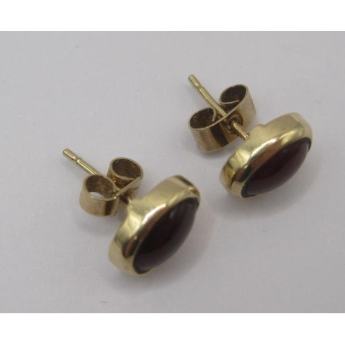 180 - Pair of cabouchon garnet earrings in yellow metal settings, one of the retainers stamped 375. With a... 