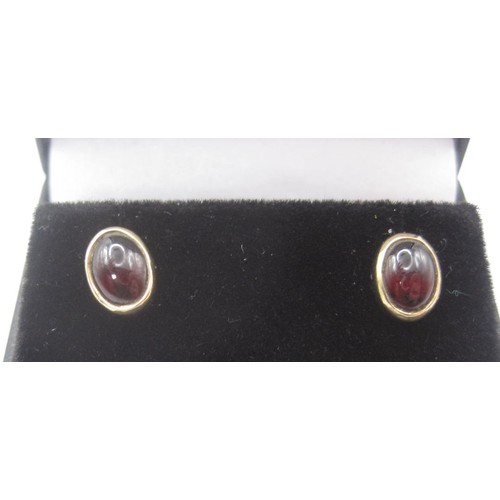 180 - Pair of cabouchon garnet earrings in yellow metal settings, one of the retainers stamped 375. With a... 